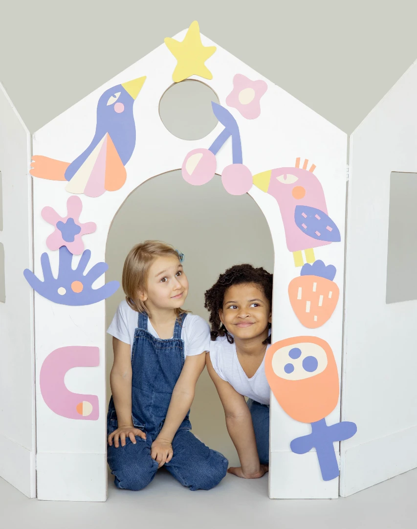 Deux jeunes filles qui jouent ensemble et qui sourient dans un espace pour enfants